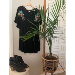 Black dress with embroidered floral detail.